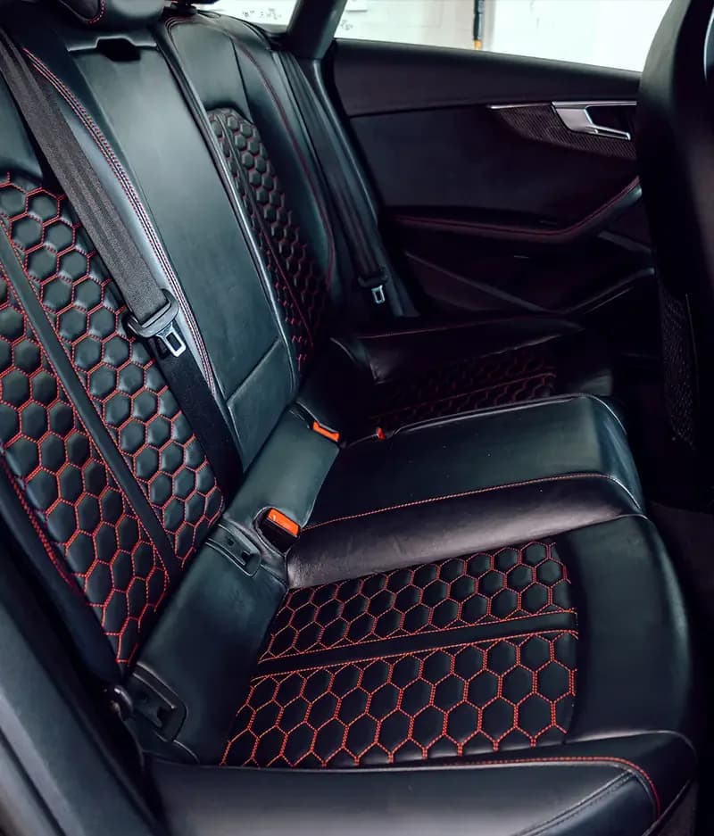 Black leather rear seats with red stitching after a Detail Pals interior detail